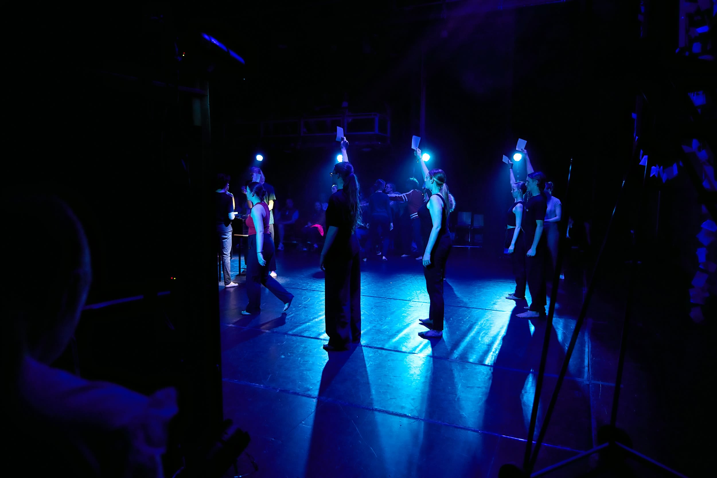 Young performers holding up white paper infant of white lights